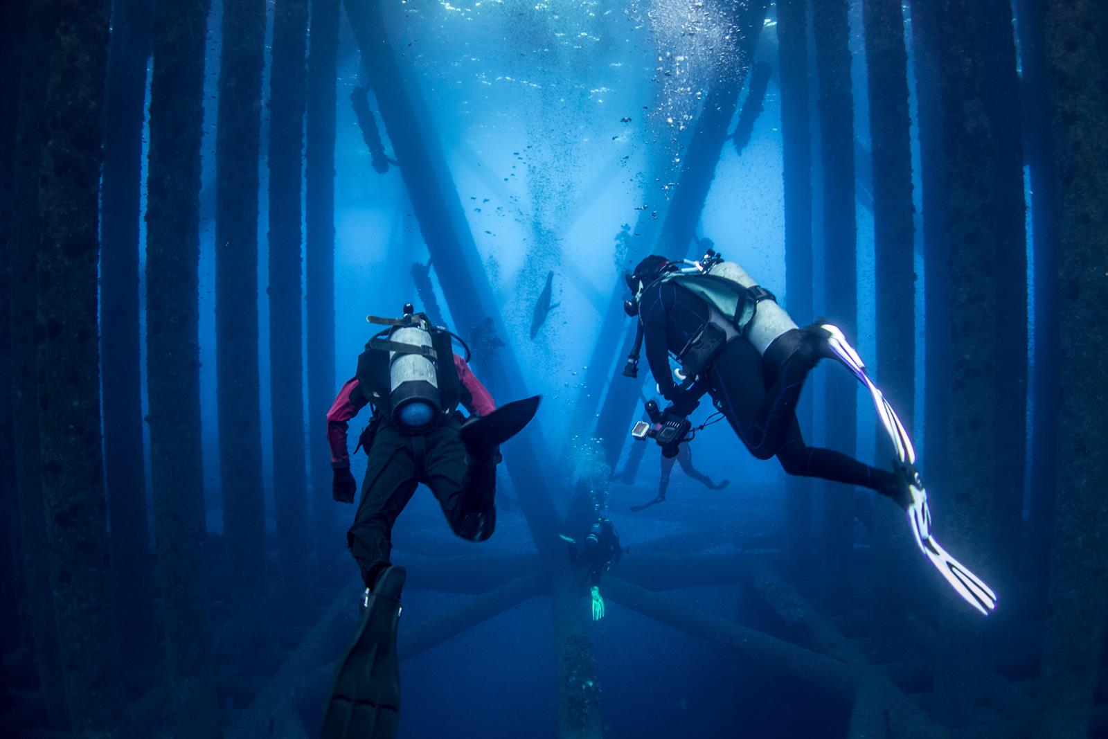 Dykkere under en offshore-platform